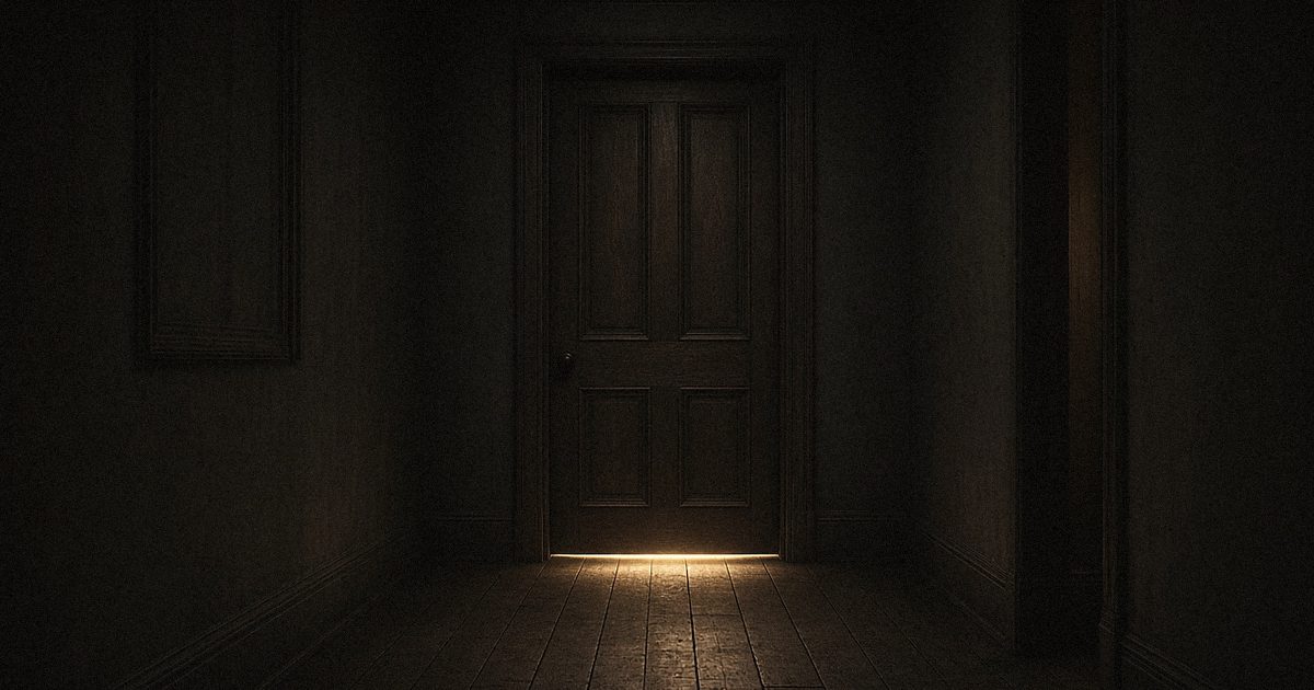 A closed door in a dark hallway with light showing underneath